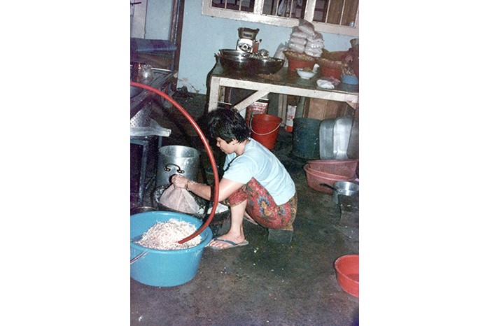 Gambar ini menunjukkan Mak Enon, tenaga kerja lama Pariaman, menyediakan bahan-bahan untuk nasi padang.